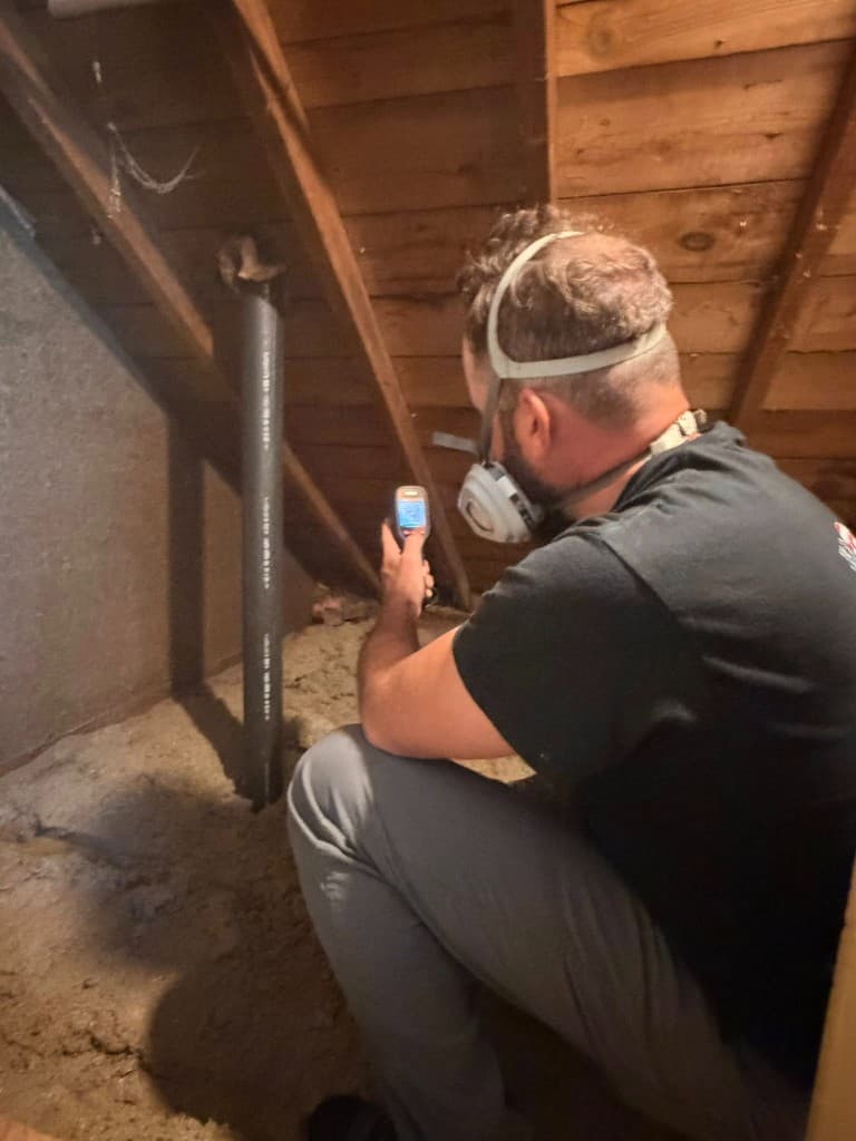 Inspector examining attic insulation and ventilation